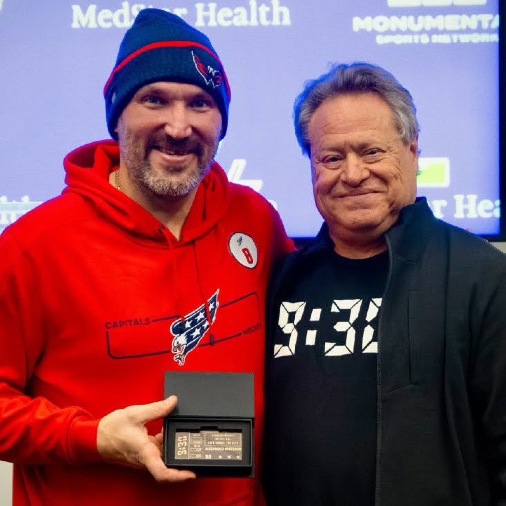 Alex Ovechkin holding his lifetime 9:30 Club golden ticket beside 9:30 Club owner Seth Hurwitz, who wears a 9:30 T-shirt.